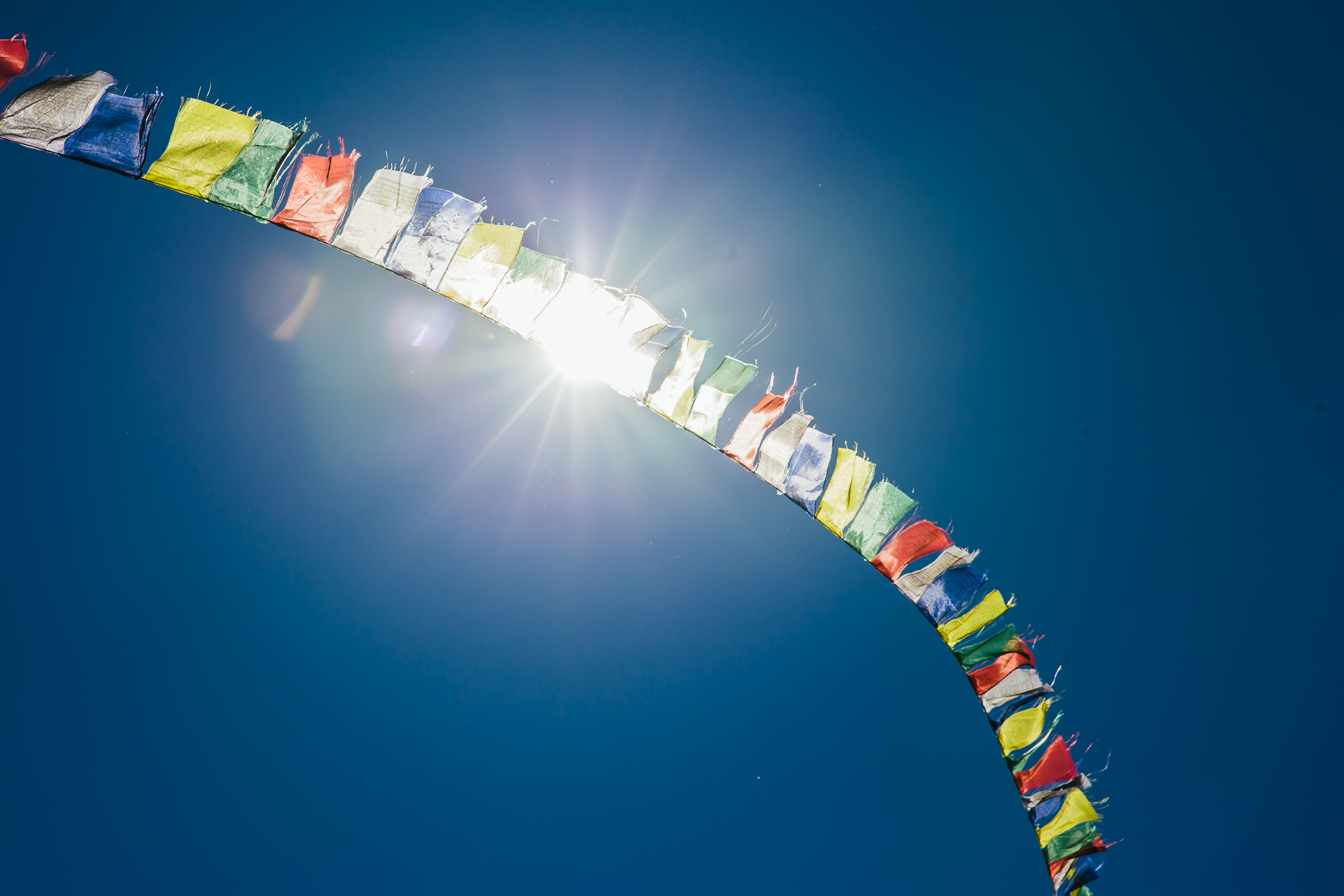 Buddhist prayer flags blowing in the blue sky